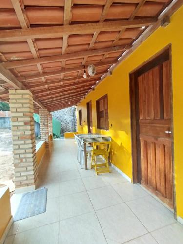 a patio with a table and a wooden ceiling at Recanto Zen centro Cumuruxatiba in Cumuruxatiba