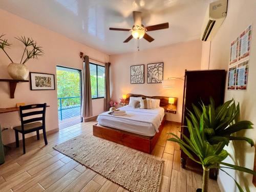 a bedroom with a bed and a ceiling fan at Kika Zaru Free park tour and breakfast in Quepos