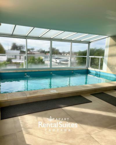 a large swimming pool in a building with windows at RENTAL SUITES CAMPANA in Campana