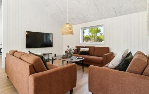 a living room with two couches and a tv at Awesome Home In Glesborg With Sauna in Fjellerup