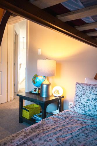 a bedroom with a bed and a table with a lamp at Entire Home AC 4Beds Sleeps 8 Double Garage Near WEM Free Wifi & Netflix in Edmonton