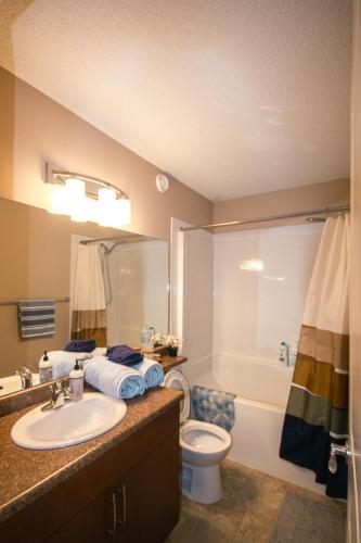 a bathroom with a sink and a toilet and a tub at Entire Home AC 4Beds Sleeps 8 Double Garage Near WEM Free Wifi & Netflix in Edmonton