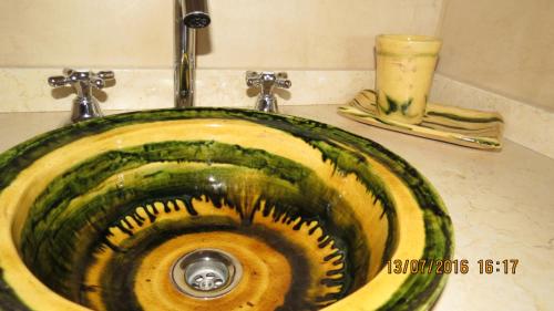 lavabo con lavabo verde y amarillo en Cabañas Entre Verde, en Los Hornillos