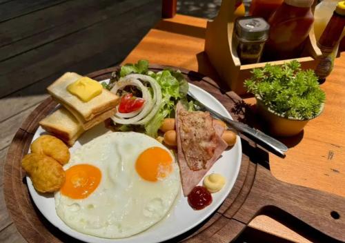 een bord ontbijtproducten met eieren en toast bij The Poom Cafe & Resort Khao Yai in Ban Khanong Phra Klang (1)