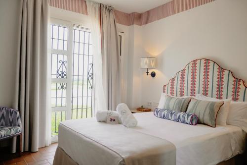 Un dormitorio con una cama y una ventana grande en Hotel Toruño del Rocío, en El Rocío