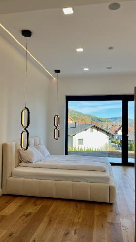 a large white bedroom with a large bed and a large window at Alpine Loft in Kapfenberg