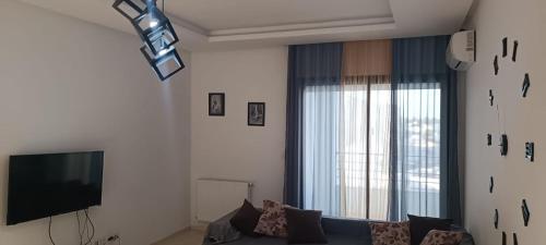 a living room with a couch and a television at Fatimides 2 in El Aouina Station