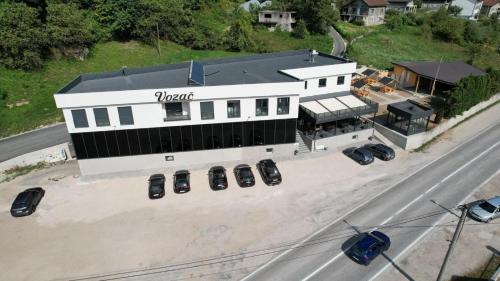 an overhead view of a white building with cars parked outside at Prenoćište Vozač in Jajce