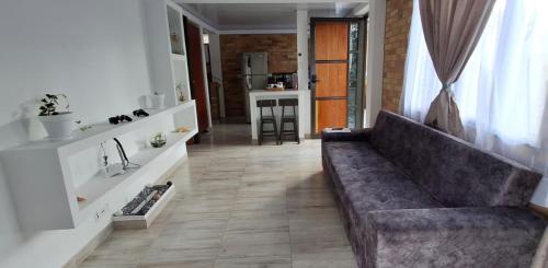 a living room with a couch and a kitchen at Cabaña privada cerca de Armenia Quiet Mountain View Country Home in Salento