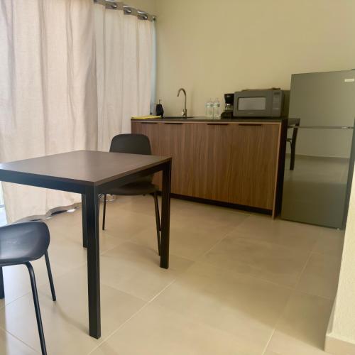 a table and chairs in a room with a microwave at MA1100 loft in Colima