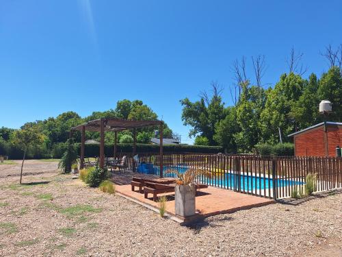 a fence with a picnic table next to a pool at El Nevado Casa de Campo 2 in San Rafael