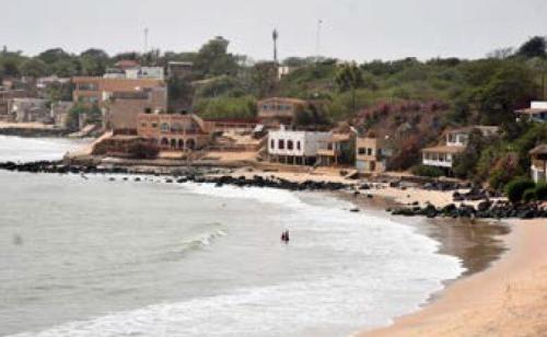 a beach with a group of people in the water at Maison Popenguine sur Mer in Poponguine