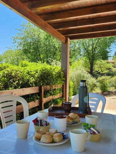 une table avec des assiettes de pain et des tasses dessus dans l'établissement Los Cantaros, à Santa Rosa de Calamuchita