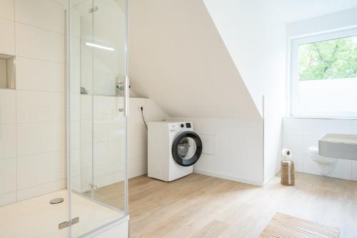 a bathroom with a shower and a washing machine at 3-Zimmer-Wohnung in Hamburg am Flughafen in Hamburg