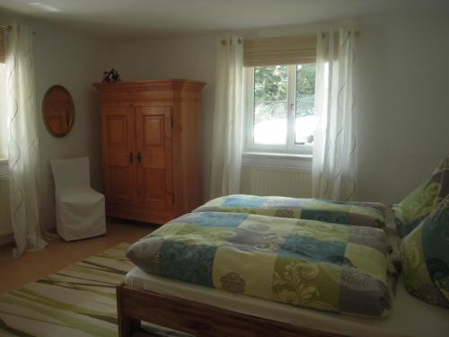 1 dormitorio con cama, ventana y vestidor en Ferienwohnung Oswald Fuschlsee, en Hof bei Salzburg