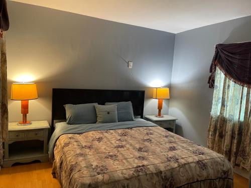 a bedroom with a bed and two lamps on two tables at Pasadena single house in Pasadena