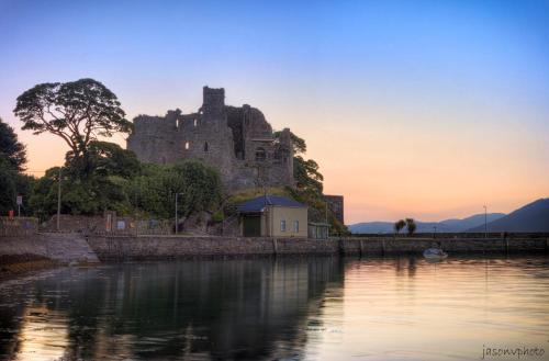 a castle sitting on a hill next to a body of water at Walkers Nest in Carlingford