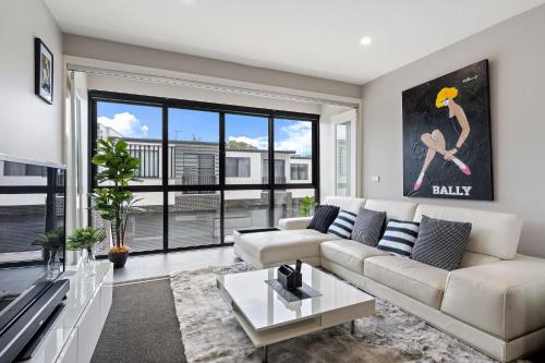 a living room with a couch and a large window at Modern 3-Bedroom Townhouse in Quiet Greenway in Tuggeranong