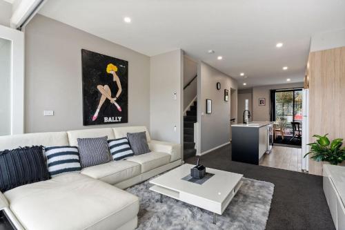 a living room with a white couch and a table at Modern 3-Bedroom Townhouse in Quiet Greenway in Tuggeranong