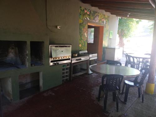 a kitchen with a table and a stove and chairs at Camping Agua Clara-EL Mundo del Rock in Miramar