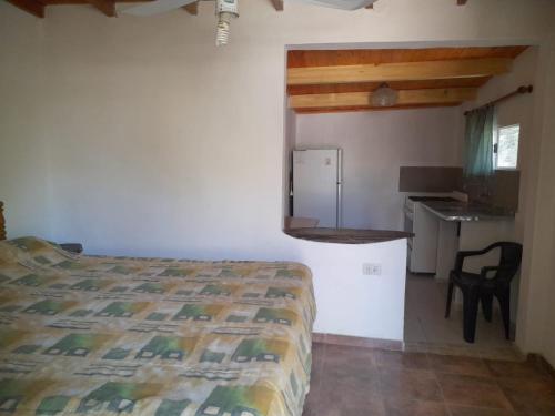 a bedroom with a bed and a desk and a kitchen at Camping Agua Clara-EL Mundo del Rock in Miramar