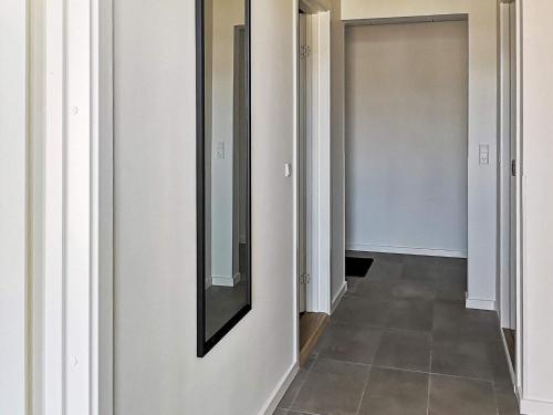 un pasillo con paredes blancas y un espejo en la pared en 8 person holiday home in Ringkøbing, en Ringkøbing