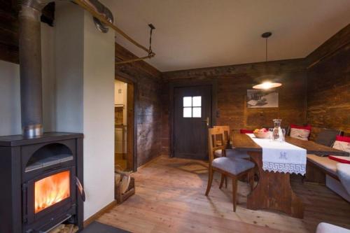a living room with a fireplace and a table and a stove at Chalet Unterleming in Angerberg
