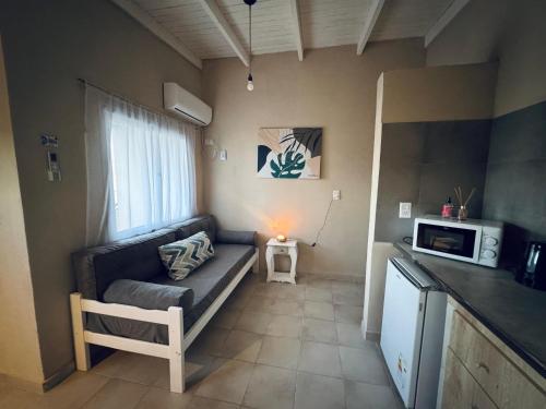 a small living room with a couch and a microwave at Apart Los Laureles Dpto 2 in Villa Regina