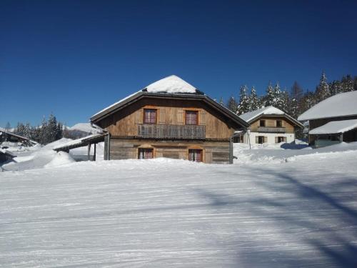 een houten huis met sneeuw op de grond bij Almchalet am Katschberg in Katschberghöhe