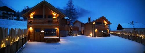 eine Blockhütte im Schnee bei Nacht in der Unterkunft Chalets Lagaun in Villetta