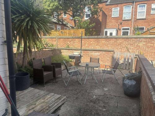 eine Terrasse mit Tisch und Stühlen und einer Backsteinmauer in der Unterkunft Stylist Double room at 1st Floor with shared bathroom in Nottingham
