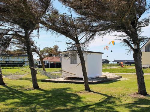 a group of kites flying in the sky behind trees at Luxury Beach Retreat - By Traum Ferienwohnungen in Løkken
