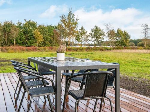 een tafel en stoelen op een terras met een veld bij 8 person holiday home in Ansager-By Traum in Ansager