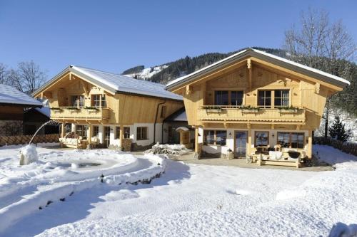 a log home in the snow with a driveway at Chalet Rustika in Goldanger