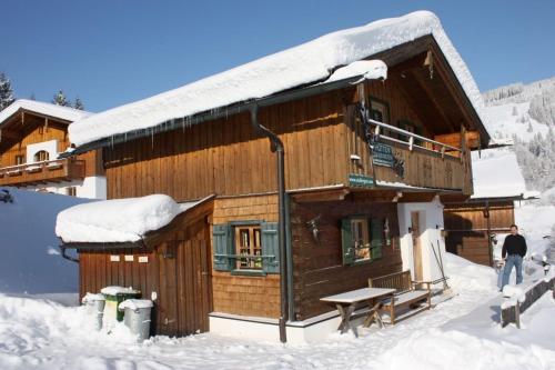 a log cabin with snow on the roof at Stallerhütte in Bachwinkl
