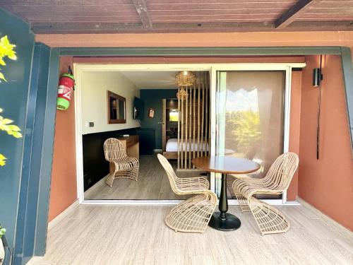 a porch with a table and chairs and a bedroom at Village Soleil in Îlet à Boissard