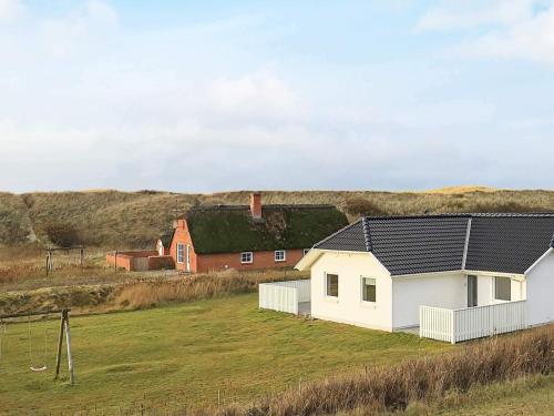 une maison blanche avec un toit noir sur un champ dans l'établissement Luxury Spa Retreat by Sea - By Traum Ferienwohnungen, à Vrist