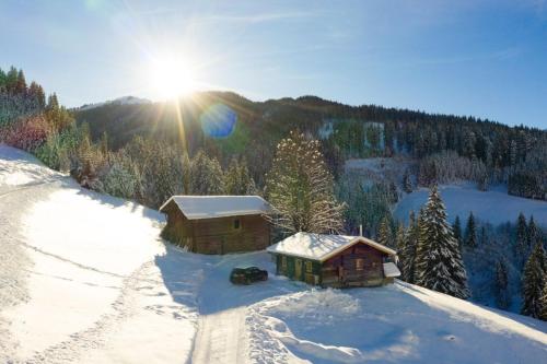 a couple of buildings in the snow on a mountain at Hungarhub Hütte in Grossarl