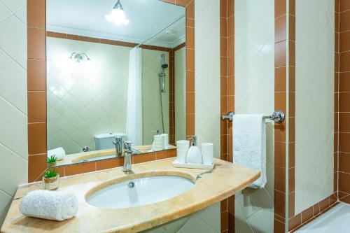 ein Badezimmer mit Waschbecken und großem Spiegel in der Unterkunft Visconde Apartment in Ribeira Brava