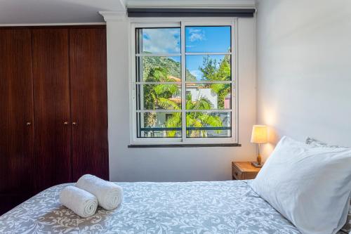ein Schlafzimmer mit einem Bett und einem großen Fenster in der Unterkunft Visconde Apartment in Ribeira Brava