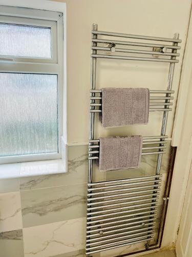 a towel rack in a bathroom next to a window at Walsall Comfort Home 3Bedroom Retreat Sleeps 6 in Bescot