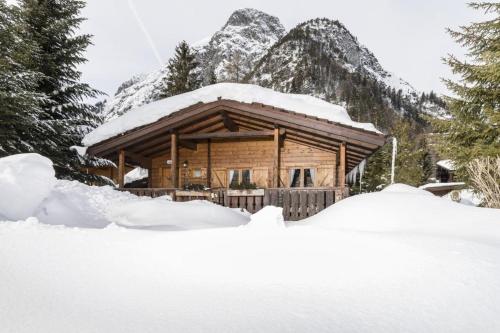 a log cabin in the mountains with snow on the ground at Alpen-Chalets Achensee in Häusern