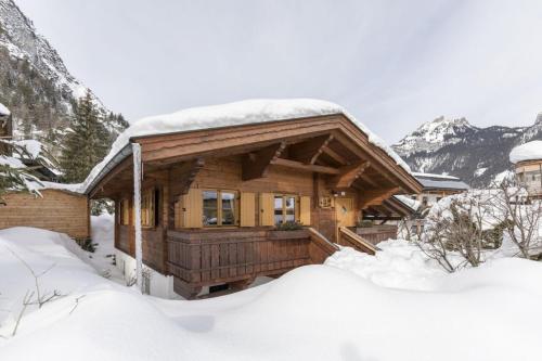 a log cabin with snow on the roof at Alpen-Chalets Achensee in Häusern