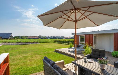 a patio with an umbrella and chairs on a deck at Nice Home In Tarm With Sauna in Højsand