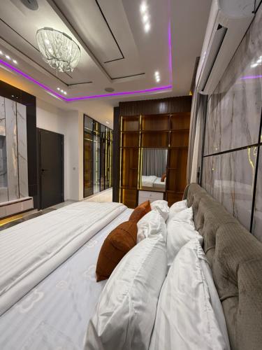 Cama blanca grande en habitación con sofá en ZELE homes, en Aja