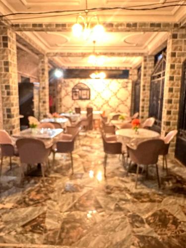 a restaurant with tables and chairs on a marble floor at Skyatlantic guesthoüse in Douala