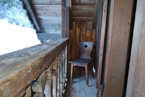a chair sitting on a porch in a cabin at Hexenhäuschen in Bachwinkl