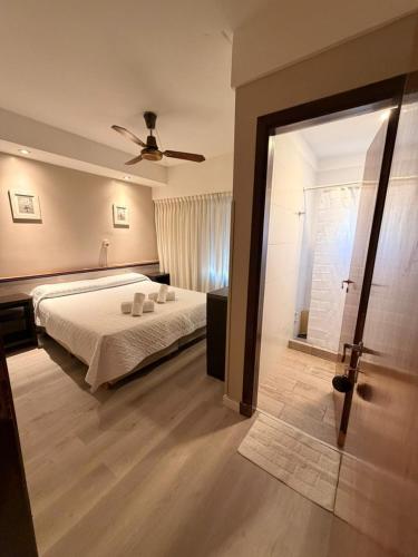 a bedroom with a bed and a ceiling fan at Hotel Don Carlos in Villa Gesell