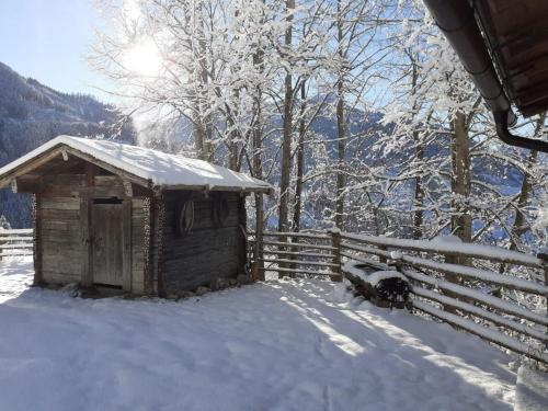a small woodenshed in the snow next to a fence at Schlickhütte in Schied