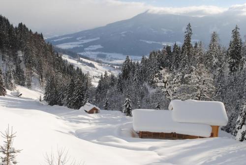 a snow covered mountain with a bench in the snow at Loimoarhütte in Bischofshofen